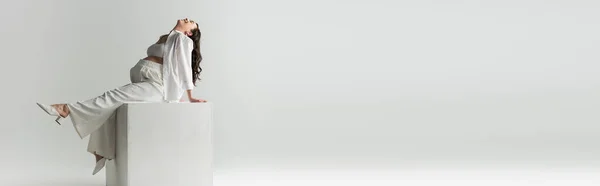 Tişörtlü Beyaz Küpün Üzerinde Oturan Gri Arka Planda Gülümseyen Hamile — Stok fotoğraf