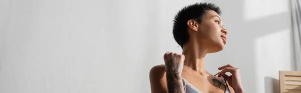 Νέα Και Σέξι Γυναίκα Τατουάζ Κοντά Καστανά Μαλλιά Αγγίζοντας Τιράντες — Φωτογραφία Αρχείου