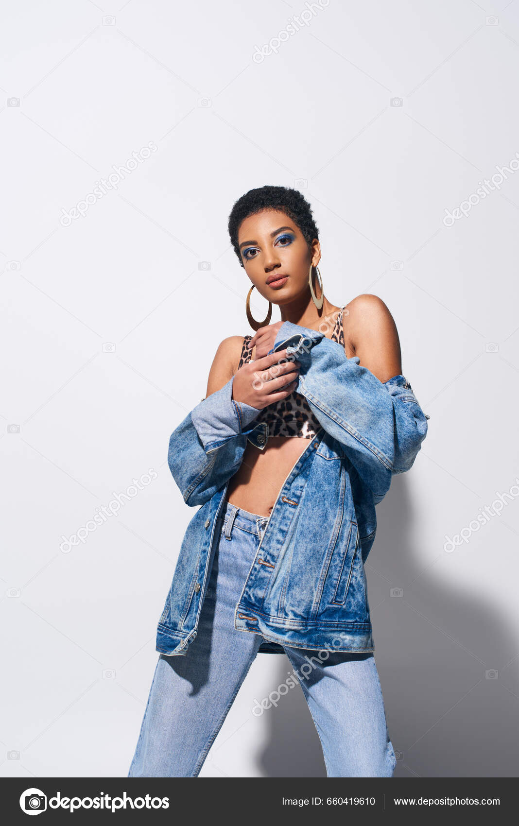 A Girl in Earrings in a Denim Jacket in Jeans in Sneakers in a Full-length  Shows Back To Left Looking Away. Fashion Concept Stock Photo - Image of  eyewear, fulllength: 177801026