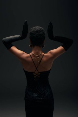 Gece elbisesi, eldivenler ve altın aksesuarlar giymiş şık Afro-Amerikan kadınlarının arkadan görünüşü, aydınlatma, yüksek moda ve akşam görünüşü, kadınsı şehvet. 