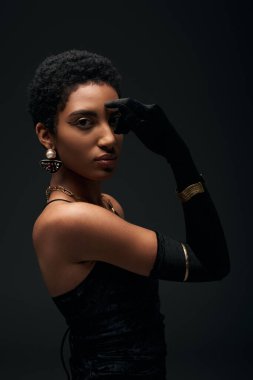 Modaya uygun ve kısa saçlı Afro-Amerikan modeller, aksesuarlar ve eldivenler siyah, yüksek moda ve akşam poz verirken göz kapatıyorlar.
