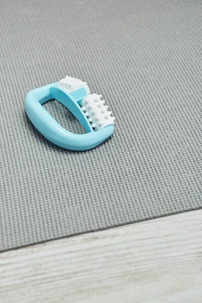 Закройте обзор ручного массажиста, лежащего на фитнес-коврике на полу дома, практики естественного здоровья и концепции домашнего массажа, красоты и велнес-процедур, здоровья и релаксации 