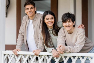 Veliler Günü kutlaması, orta yaşlı bir kadının neşeli kızıyla ve oğluyla birlikte yazlık evin verandasında fotoğraf makinesine, aile toplantısına, kaynaşmaya, modern ebeveynliğe bakıp hatırlanması gereken anlar. 