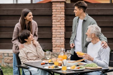 Haziran 'da arka bahçede veliler günü kutlamalarında çocuklarla konuşurken pozitif aile sohbeti, aile sevgisi, gelenek ve kutlama.