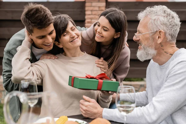 Positive Children Hugging Middle Aged Mother Father While Spending Time — Stock Photo, Image