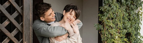 Sorridente Giovane Uomo Abbracciando Felice Mamma Mezza Età Mentre Piedi — Foto Stock