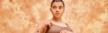 body positivity movement, curvy and tattooed woman in crop top posing on mottled beige background, looking away, representation of body, different body shapes, generation z, youth, banner  clipart