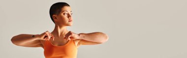 Vücut çeşitliliği, dövmeli ve kısa saçlı kadın gri arka plan, spor giyim, güçlendirme, motivasyon, güç ve sağlık alanlarında kıvrımlı spor modelleri, afiş,