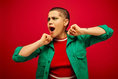 emotional, bold makeup, generation z, youth culture, shocked young woman with short hair posing with opened mouth on red background, youth culture, vibrant background, stylish appearance  clipart