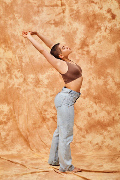 Джинсовая мода, ген z, молодая пышная женщина с татуировкой растяжения на пятнистом бежевом фоне, различные формы, движения положительность тела, самооценка, уверенность, короткие волосы модель, молодежная культура 