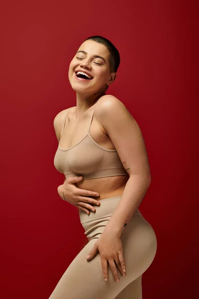 Körperpositive Glückliche Und Tätowierte Frau Beiger Unterwäsche Posiert Auf Rotem — Stockfoto