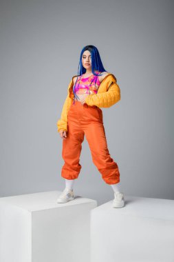 beauty and fashion trends, young tattooed woman with blue hair posing in colorful clothes on grey background, full length, white cubes, individualism, modern style, urban fashion, vibrant color  clipart