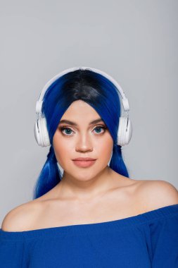 music lover, young woman with vibrant hair listening music in wireless headphones on grey background, youth, individualism, modern subculture, self expression, sound  clipart