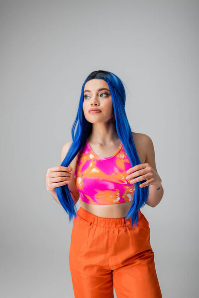 self expression, young woman with blue hair posing and looking away on grey background, isolated, fashion choices, stylish look, colorful clothes, casual attire, generation z fashion, long hair