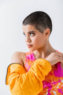 Makyaj ve tarz, kısa saçlı bir kadının portresi gri arka plan, z nesli, trend, moda ileri, kadın modeli, kendini ifade etme, günlük giysiler 