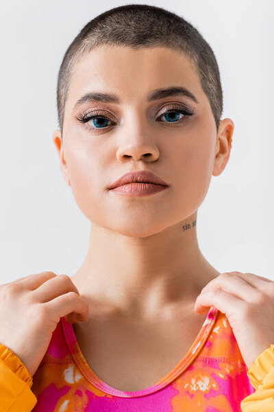 makeup and style, portrait of tattooed young woman with short hair looking at camera on grey background, generation z, fashion forward, female model, self expression 