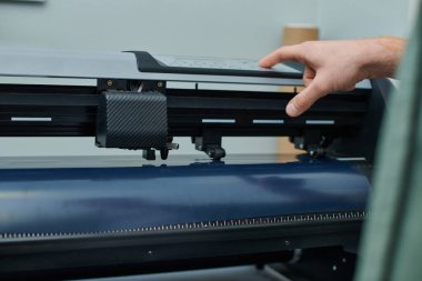 Baskı stüdyosundaki işlemler sırasında ekran baskı makinesi kullanan genç zanaatkârın kırpılmış görüntüsü, proje üzerinde çalışan küçük işletme sahibi, yazdırma, yaratıcı süreç, iş akışı 