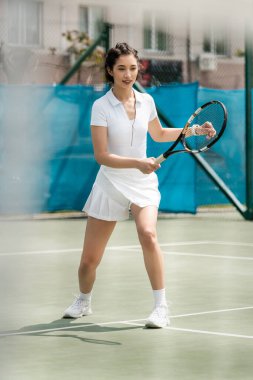 Spor elbiseli mutlu bayan oyuncu tenis kortunda raket tutuyor, yaz sporu, hobi ve sağlık