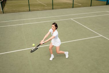Forehand, aktif kadın oyuncunun genel görünümü tenis, raket ve top oynarken giyiliyor, spor