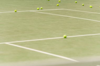 nobody on shot, tennis balls on spacious court, blurred foreground, summer, sport and leisure clipart