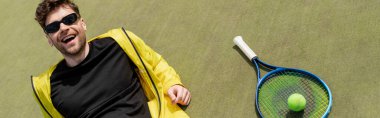 Pankart, güneş gözlüklü mutlu adam tenis topu ve raketin yanında dinleniyor, tenisçi, spor ve tarz