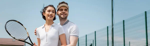 stock image banner, romance on tennis court, happy man teaching girlfriend how to play tennis, summer sport