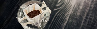 Siyah masaya filtre poşet içinde aromatik öğütülmüş kahve bardağı dökme metodu, afiş