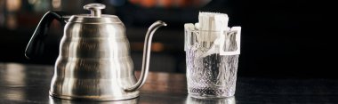 Üzerine espresso dök, aromatik kahve bardağı kağıt torbada, siyah masada su damlası, afiş.