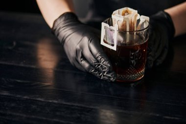 Dökümlü bira yapma yöntemi, siyah lateks eldivenli barista 'nın yanında kağıt filtre torbada kahve bardağı. 