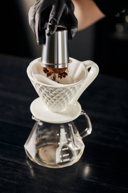 Kahve barmeni jigger 'dan seramik damlatıcıya V-60 tarzı espresso dolduruyor.