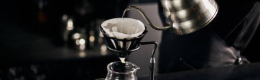 barista pouring boiling water into coffee filter on dripper stand above glass pot, V-60 style, banner clipart