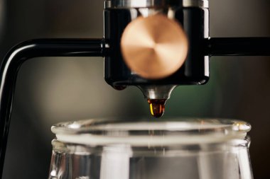 Yeni demlenmiş kahve makinesiyle modern sifon kahve makinesinin yakın görüntüsü bulanık ön planda.