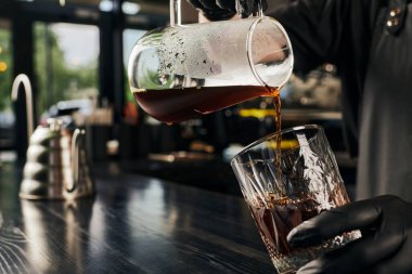 Kahve makinesinden kahve bardağına aromatik espresso döken baristanın kısmi görüntüsü