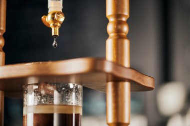 Kahve dükkanı, soğuk serinletici espresso, taze su öğütülmüş kahveye damlıyor, manzarayı kapat.