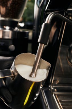 cropped view of barista frothing milk in pitcher, foaming milk, professional coffee machine, latte  clipart