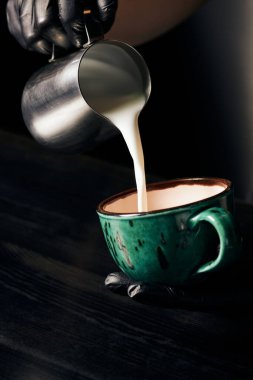 Lateks eldivenli barista cappuccino, taze espresso, latte sanat, sürahi, süt doldurma 