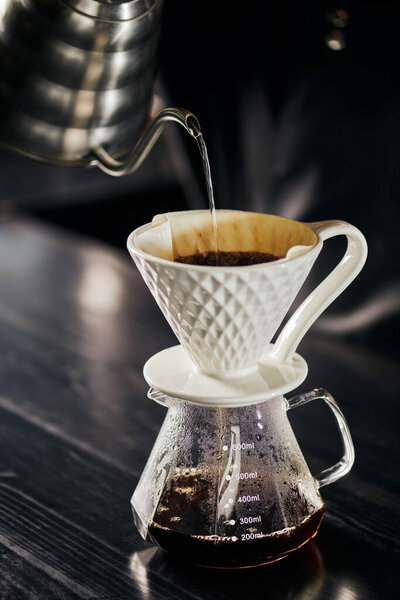 alternative V-60 style espresso brew, boiling water pouring into ceramic dripper placed on glass pot