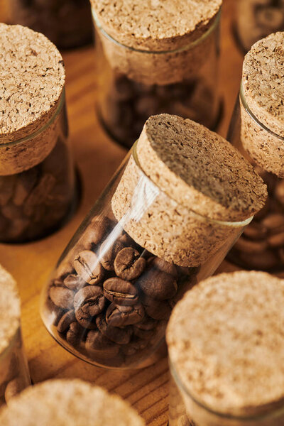 coffee beans in glass jars with cork, roasted, caffeine and energy, coffee background, macro 