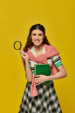 happy young woman holding books and magnifier, zoom, discovery, student in college outfit, smile clipart