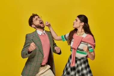 fight, brunette young woman punching man on yellow backdrop, tension, conflict, confrontation clipart