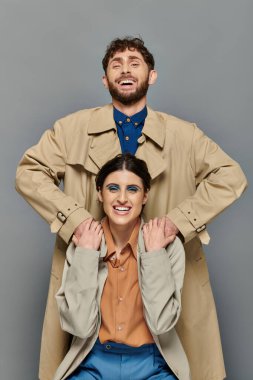 positive couple, outerwear, fall season, grey background, man and woman in trench coats, style clipart
