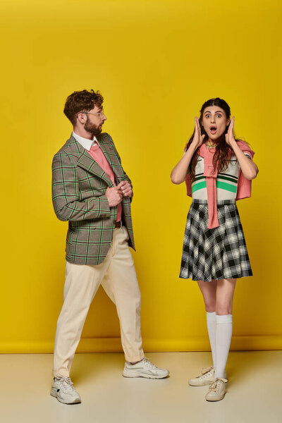 surprised man looking at shocked woman, yellow backdrop, open mouth, wow, amazed, emotional students