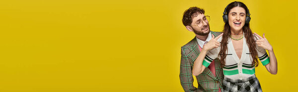 счастливая женщина, указывающая на наушники, слушая музыку рядом с босоногим мужчиной, студенты колледжа, баннер