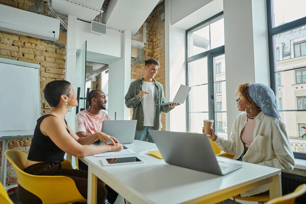 Счастливый человек, обсуждающий проект с лидером африканской команды и коллегами, разнообразие
