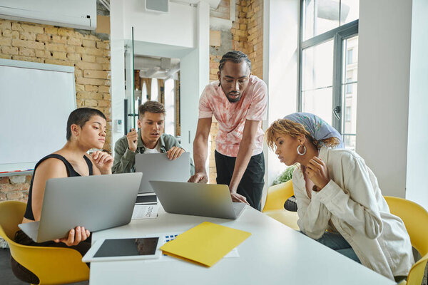 Различные бизнес-люди обсуждают идеи стартапов и планирования вблизи гаджетов, коворкинга, цифрового века