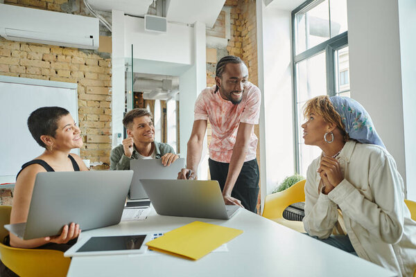 Различные бизнес-люди обсуждают стартап идеи и планирование вблизи гаджетов, коворкинг, лидерство