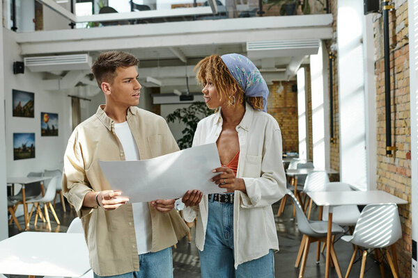 happy man and woman planning project, holding paper, interracial business people, startup, coworking