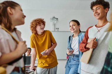 Okulda sınıfta dikilirken notları ve cihazları olan pozitif sınıf arkadaşları konuşuyorlardı.