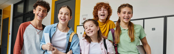 banner, teenage schoolkids looking at camera and standing in school hallway, teen classmates