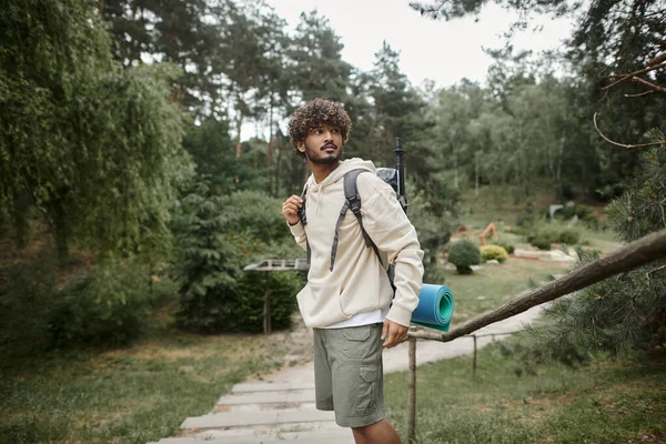 stock image young indian traveler with backpack and trekking poles standing in forest